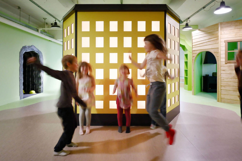 Tre barn leker i utställningen lilla arbetets museum.