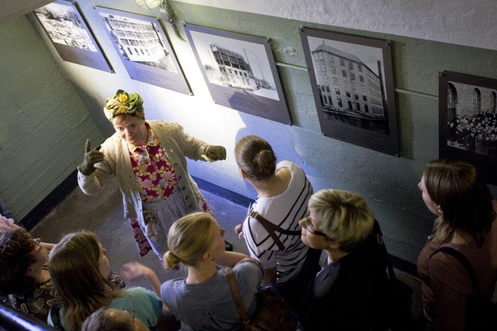 Pedagog visar utställning för publik.