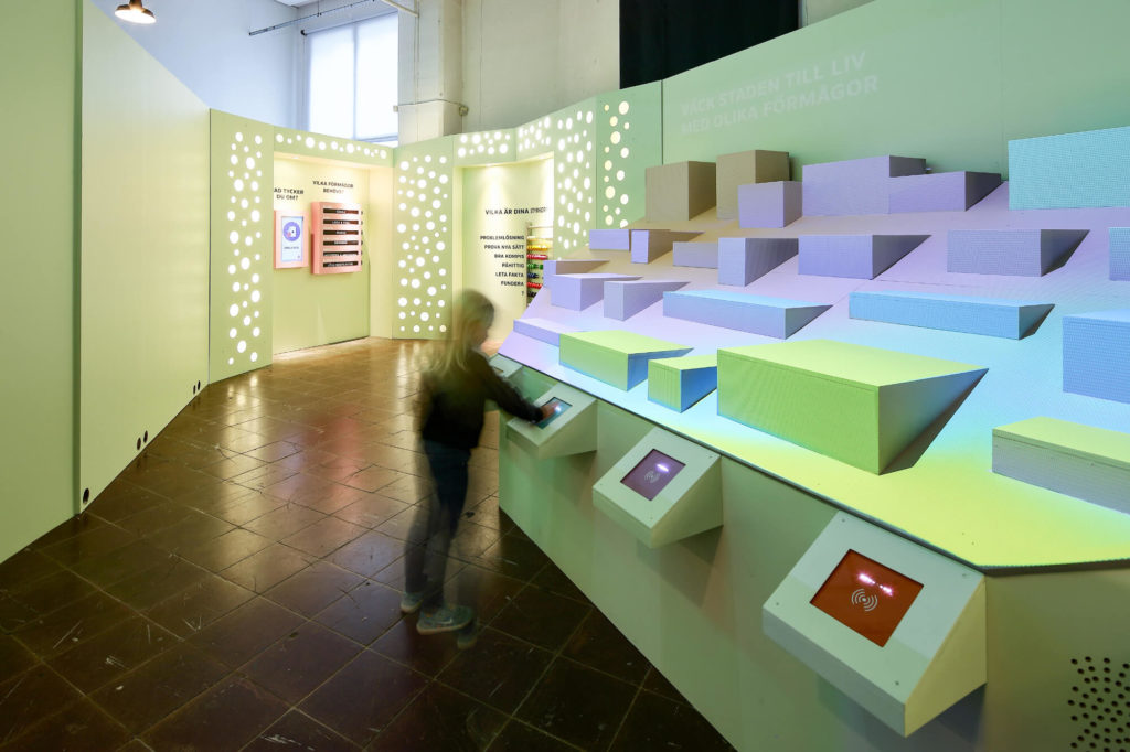 Ett barn interagerar med en skärm i utställningen Jobblabb.