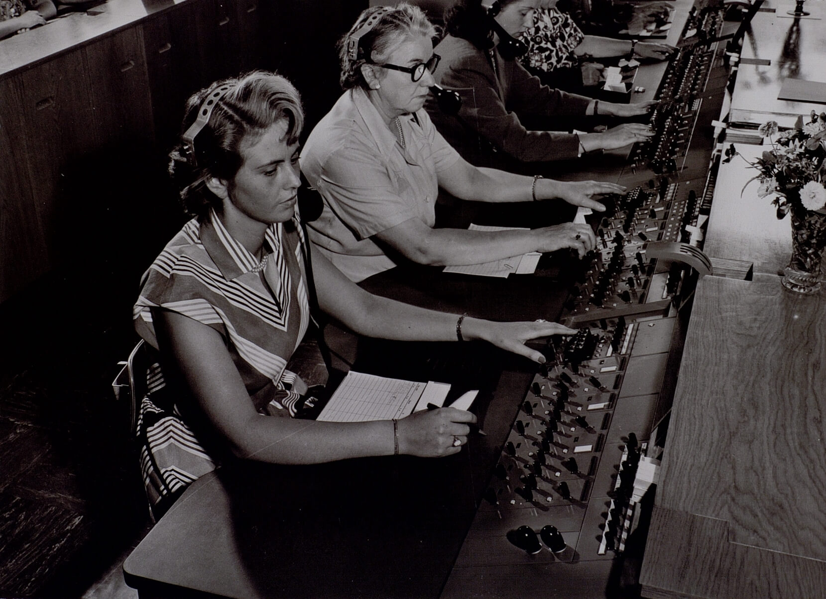 Svartvit bild på två kvinnliga utlandstelefonister i arbete.