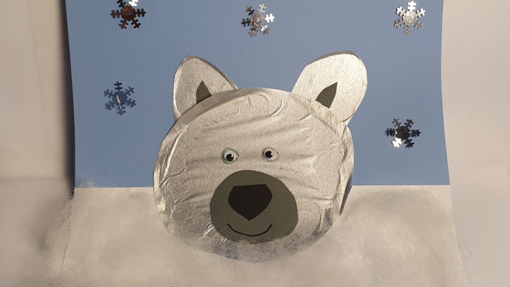 vinterpyssel med en glad isbjörn på fluffig snö med stjärnpaljetter i bakgrunden.