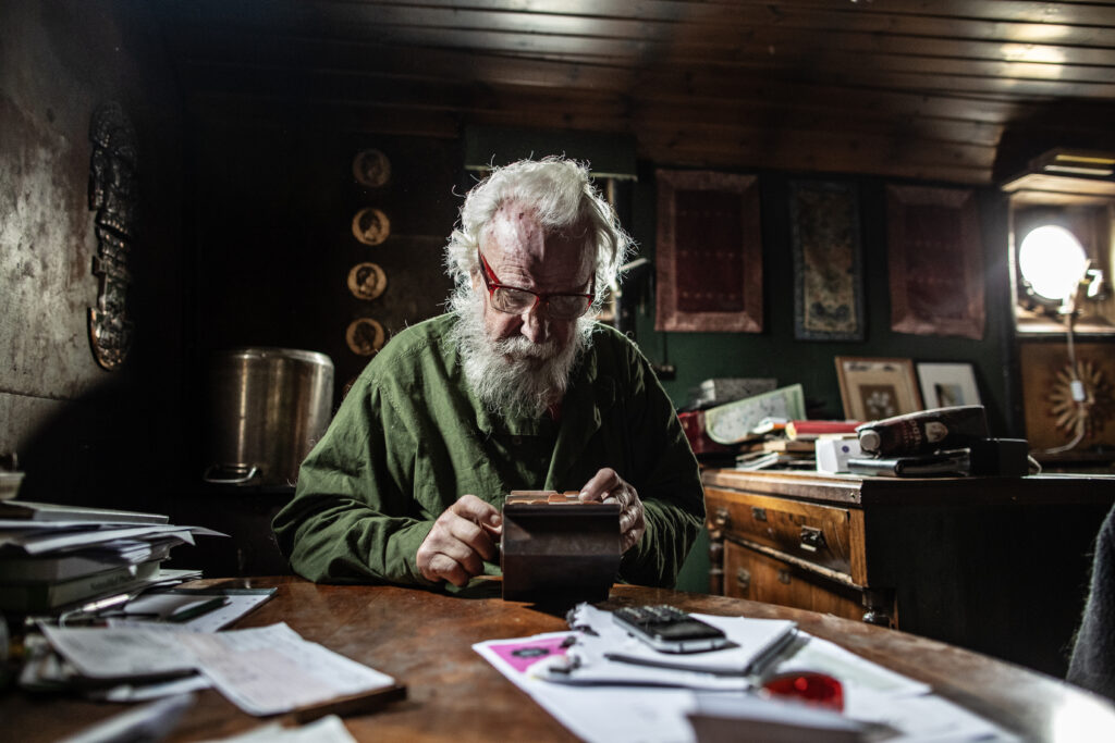 Hasse Andersson ombord på sin båt i drömmarnas kaj, letandes efter sin dotters telefonnummer i kartoteket.